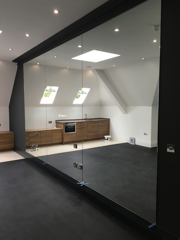 Frameless glass partition in loft conversion by Lambeth glaziers