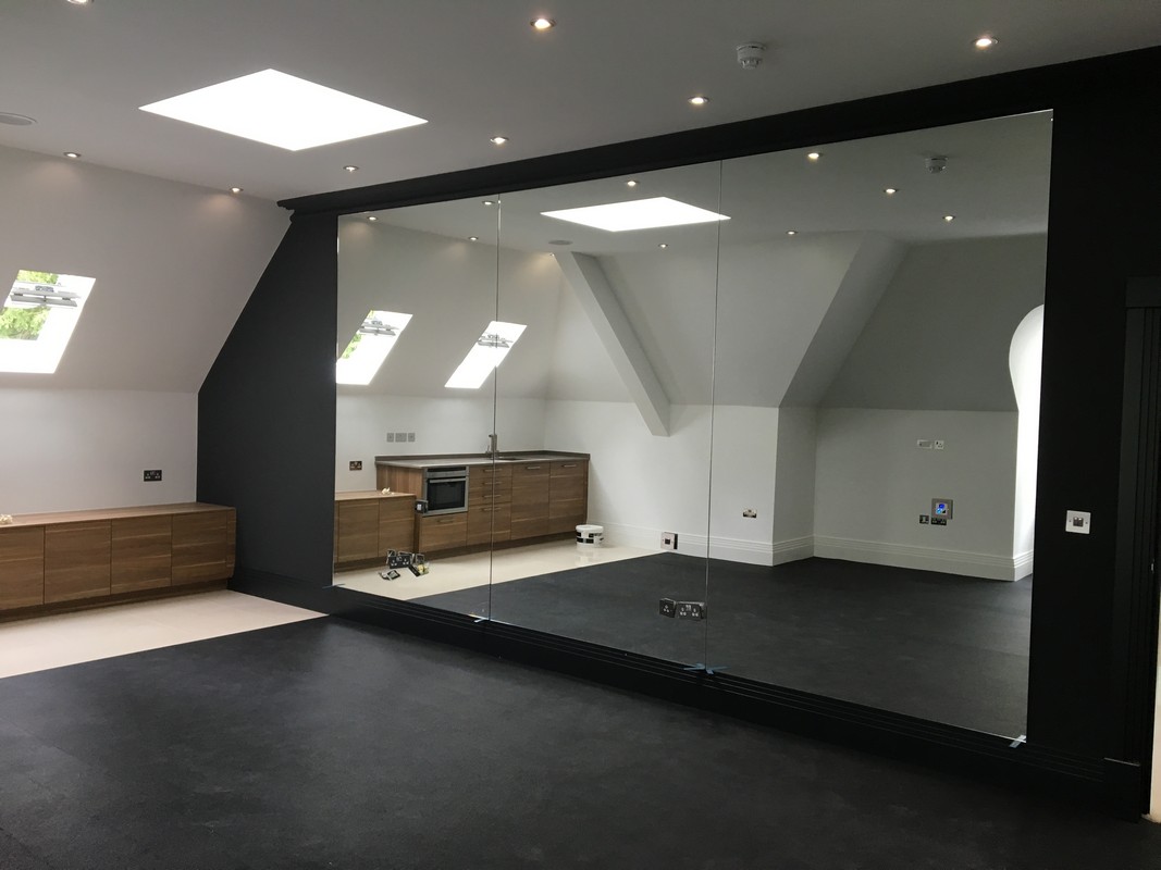 Frameless glass wall dividing loft conversion in Lambeth